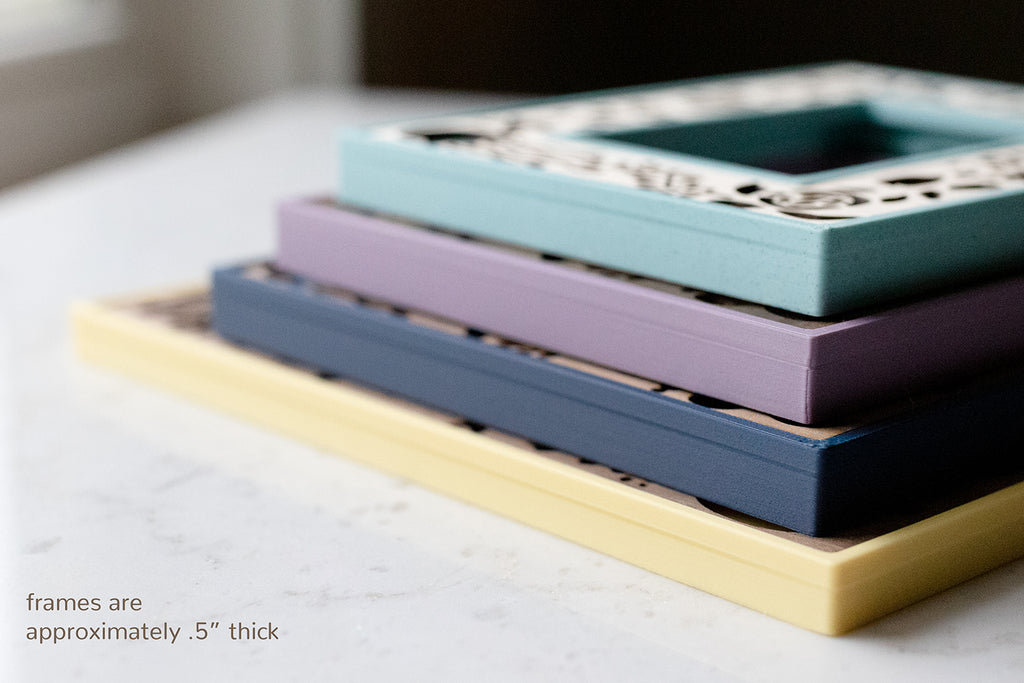 Custom 3D printed and laser cut picture frame housings in blue, purple, and yellow