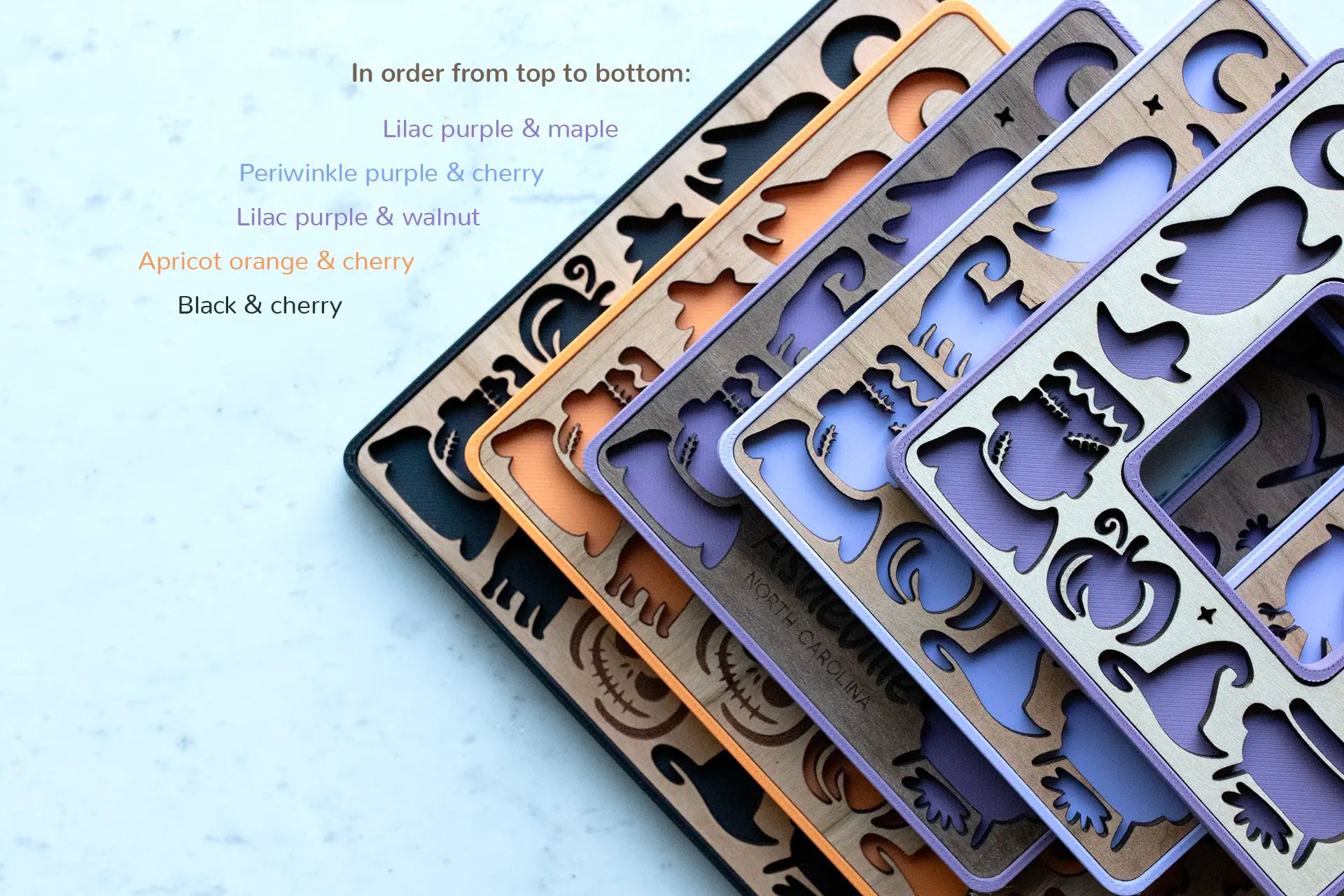 Mini Halloween decor picture frames with laser cut Halloween shapes, including black cats, ghosts, and pumpkins. Frames are available in purple, orange, and black with wooden inlays.