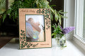 Personalized Irish wedding shamrock picture frame, laser-cut clover in cherry wood over moss green, displaying a bride and groom's wedding photo, engraved "Mick & Patty, October 10, 2026".