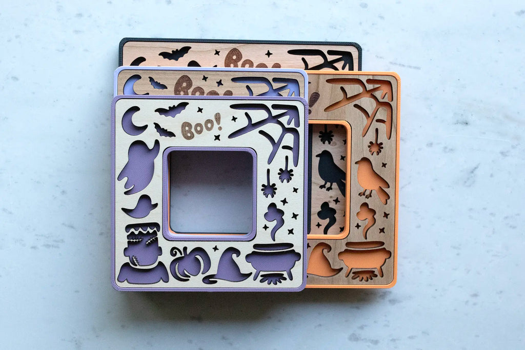 Mini Halloween keepsake picture frames with laser engraved Boo! and laser cut pumpkins, ghosts, and little Frankenstein. Frames come in purple, orange, and black.