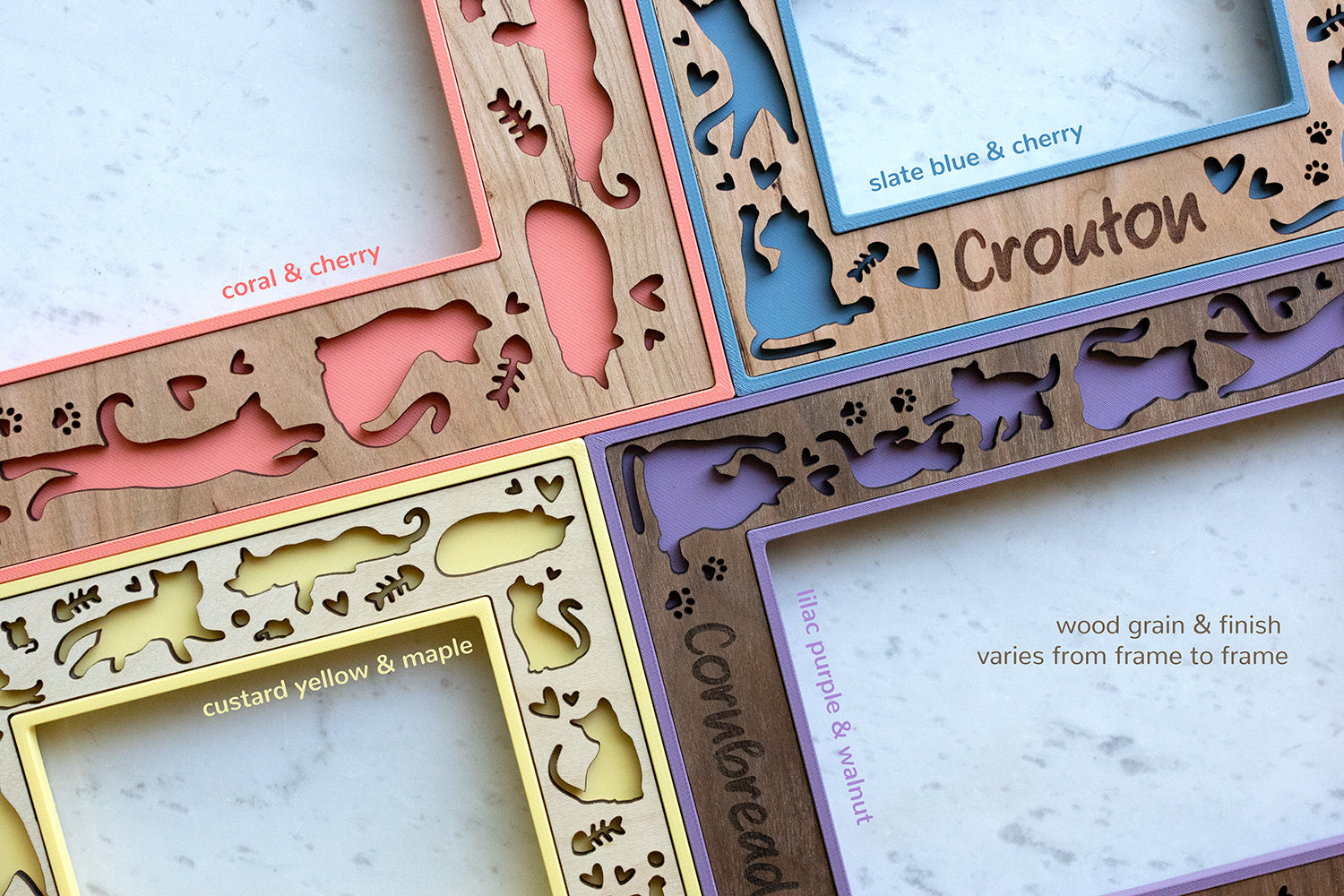 Custom laser cut cat picture frames with wood inlays that come in a variety of wood types and colors. Frames are 3D printed, and wood inlays are laser cut and engraved with custom messages and cat names. Pictured cat frames are pink, purple, slate blue, and yellow.