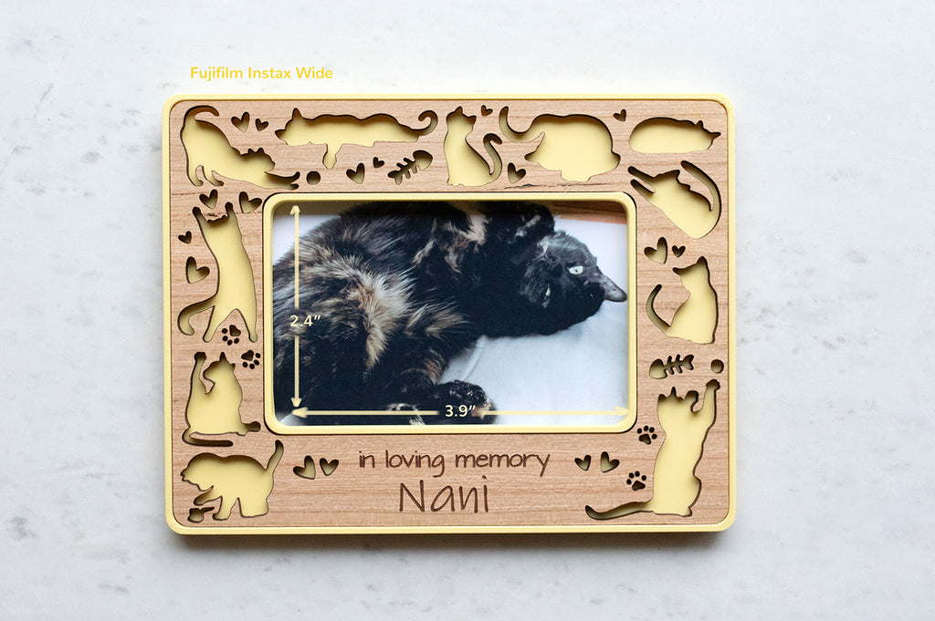 A small magnetic frame for the fridge that reads "in loving memory Nani" in engraved message across the bottom. The frame features cute laser cut cats and a yellow housing. Personalized engraving makes a great gift for cat lovers and those who have lost a beloved cat. The photo opening in the frame is 2.4" x 3.9".