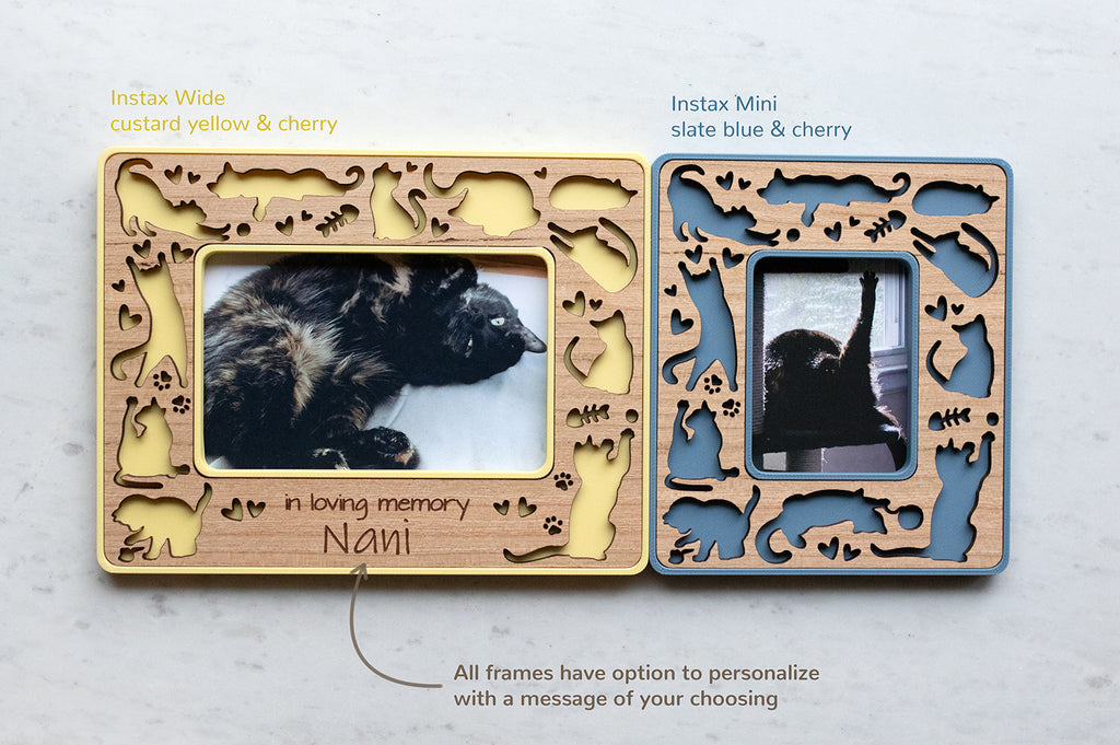 Two cute mini magnetic cat frames in instax wide and instax mini. The frames featured are blue and yellow with cherry wooden inlays. There is a note that reads "all frames have option to personalize with a message of your choosing." These personalized frame make a great cat lover gift.