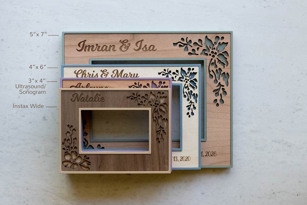 A stack of four picture frame sizes in various colors and wood styles. On top is the polaroid frame available to fit Fujifilm Instax Wide film, followed by an ultrasound frame 3x4, a 4x6 picture frame, and a 5x7 picture frame.
