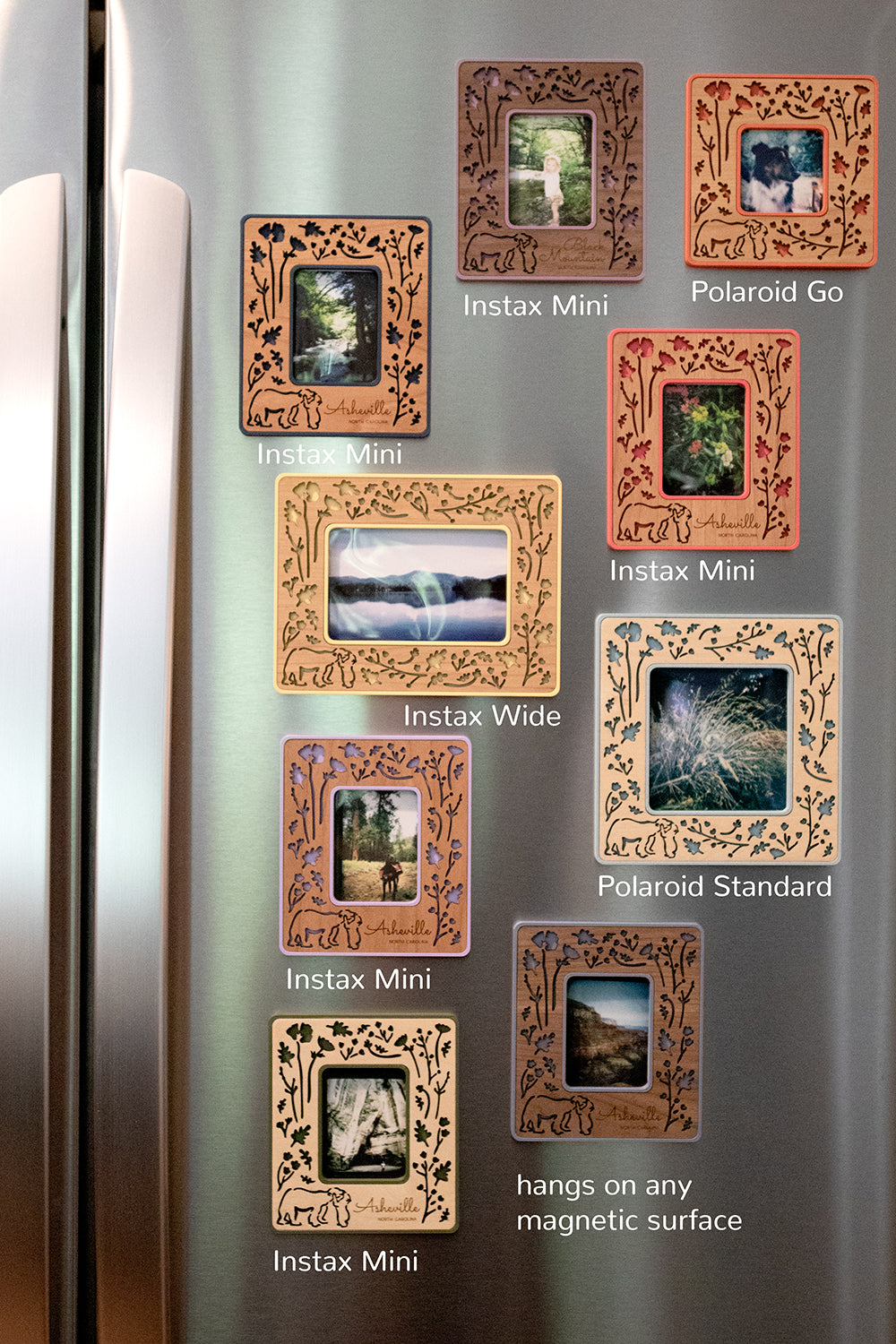 An assortment of nine laser cut Polaroid photo frames in various sizes, colors, and wood types. The magnetic frames are mounted to the front of a refrigerator and displaying Polaroid photos, Fujifilm Instax Mini photos, and Instax Wide photos.