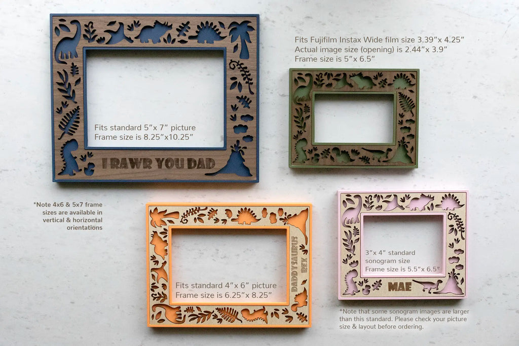 A collection of dinosaur keepsake picture frames for kids rooms. Available in various sizes and colors, each featuring a cute dinosaur theme. The frames include engraved text that reads "RAWR YOU DAD" and "DADDYSAURUS REX". Frame sizes include 5x7, 4x6, 3x4 Sonogram, and Instax Wide.