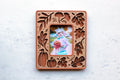 Terracotta and cherry wood fall leaves magnetic frame for Instax Mini photos, with laser-cut autumn leaf, ginkgo, and pumpkin cutouts, holding a Halloween photo of a toddler in costume with a jack-o’-lantern pail.