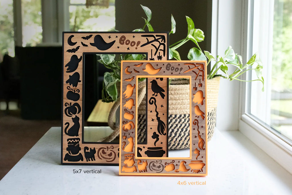 Black and orange halloween frames with laser cut wooden inlays, featuring black cats, a haunted night sky, cute ghosts, and pumpkins. Frames are made-to-order and are available in a variety of colors and wood types with the option for custom engravings.