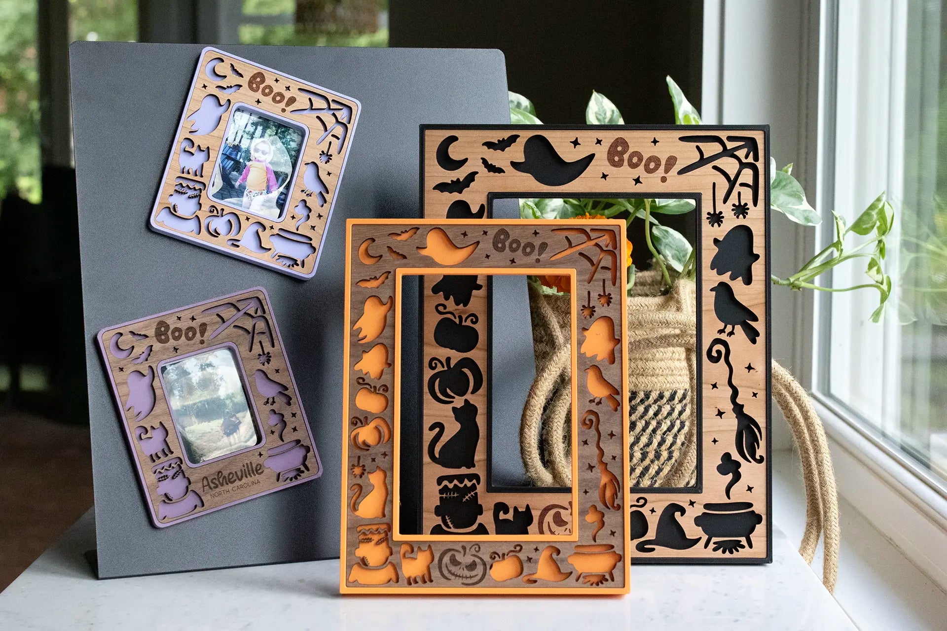 Hand crafted Halloween picture frame in laser-cut wood — black cats, bats, ghosts, pumpkins, and a "Boo!" design around the photo opening. Available in black, orange, and purple.