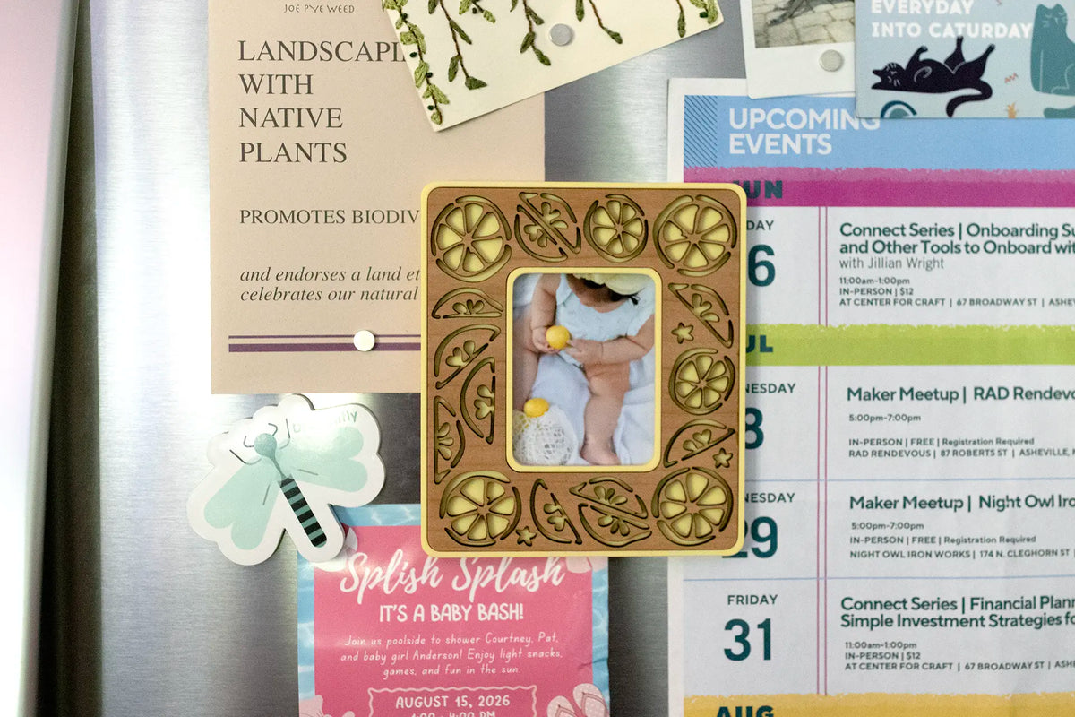Whimsical lemon frame on refrigerator. This Instax Mini frame has a magnetic back and can hold polaroid photos or photos cut to size. The frame is pictured holding papers and invitations on a fridge, making a cute piece of lemon kitchen decor.
