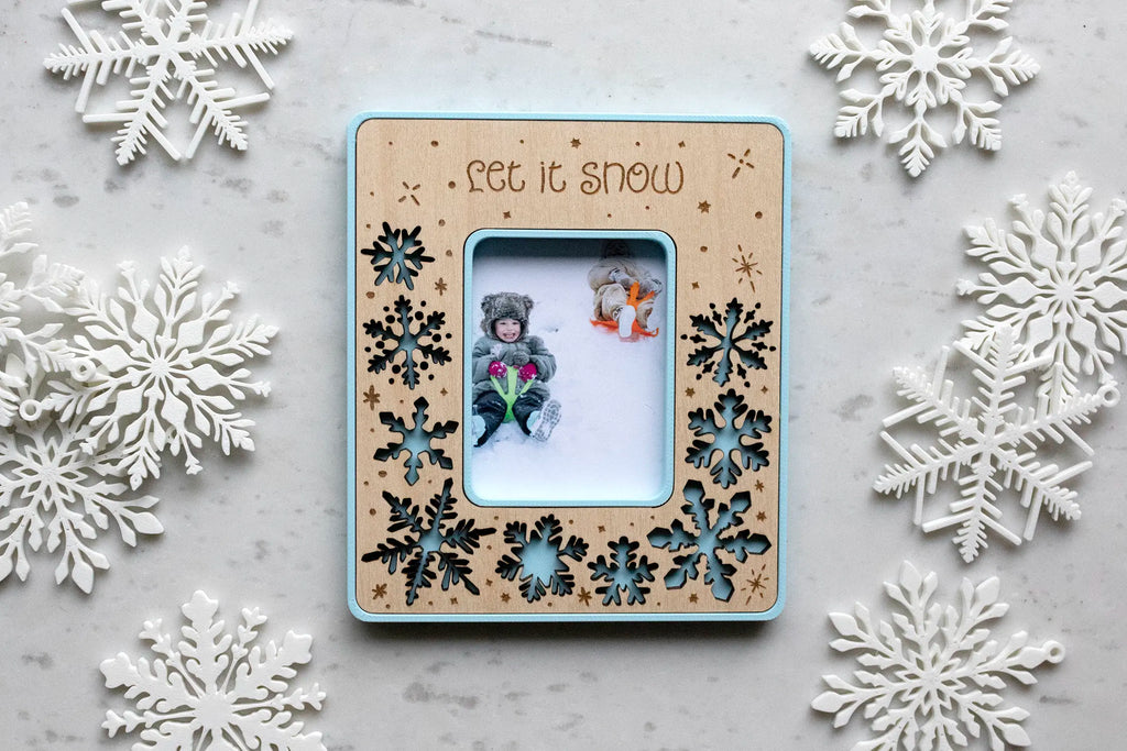 Personalized snowflake magnetic picture frame for winter home decor. This Instax Mini frame is laser-cut with delicate snowflakes and engraved with falling snow. Designed to hold your favorite Instax Mini photo or a wallet photo trimmed to size.