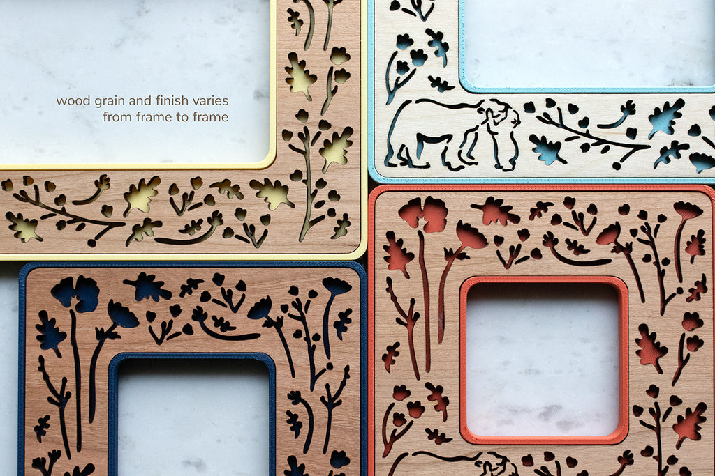 A close-up detail view of four magnetic Polaroid frames with mama and baby bear laser cut design. The message in the top-left corner of the image reads "wood grain and finish varies from frame to frame."
