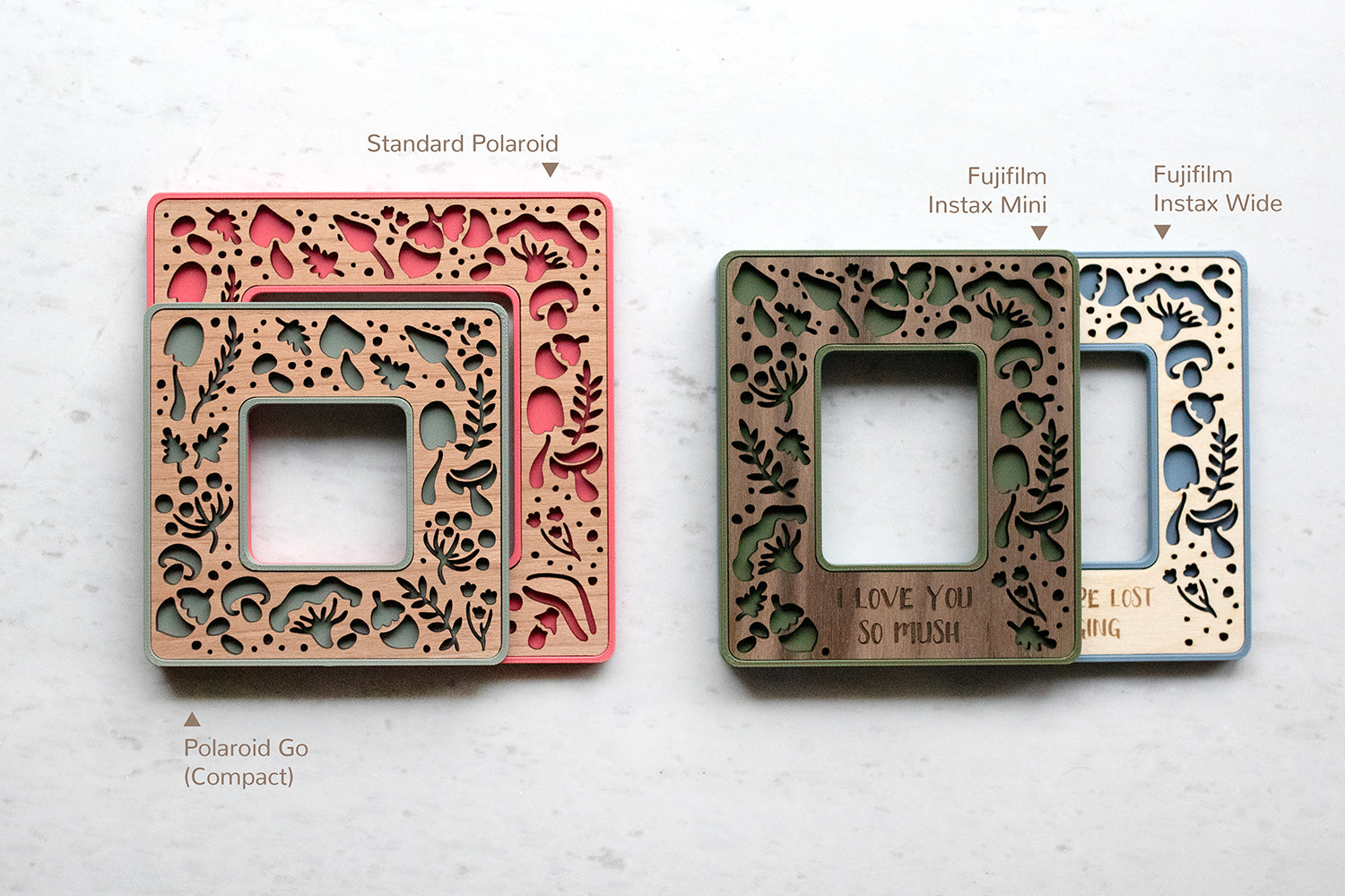 Four mini polaroid frames and Instax mini and Instax wide frames. The frames feature laser cut mushrooms, acorns, and other woodland designs. On the left, the compact Polaroid Go size is stacked on top of the larger Standard Polaroid size. On the right, the Fujifilm Instax Mini frame is stacked on top of the Instax Wide frame, showing approximate sizing.
