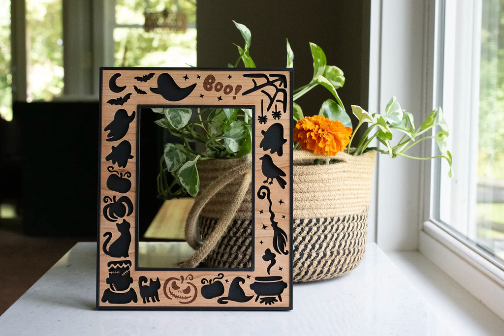 Handmade Halloween picture frame in laser-cut wood — black cats, bats, ghosts, pumpkins, and a "Boo!" design around the photo opening.