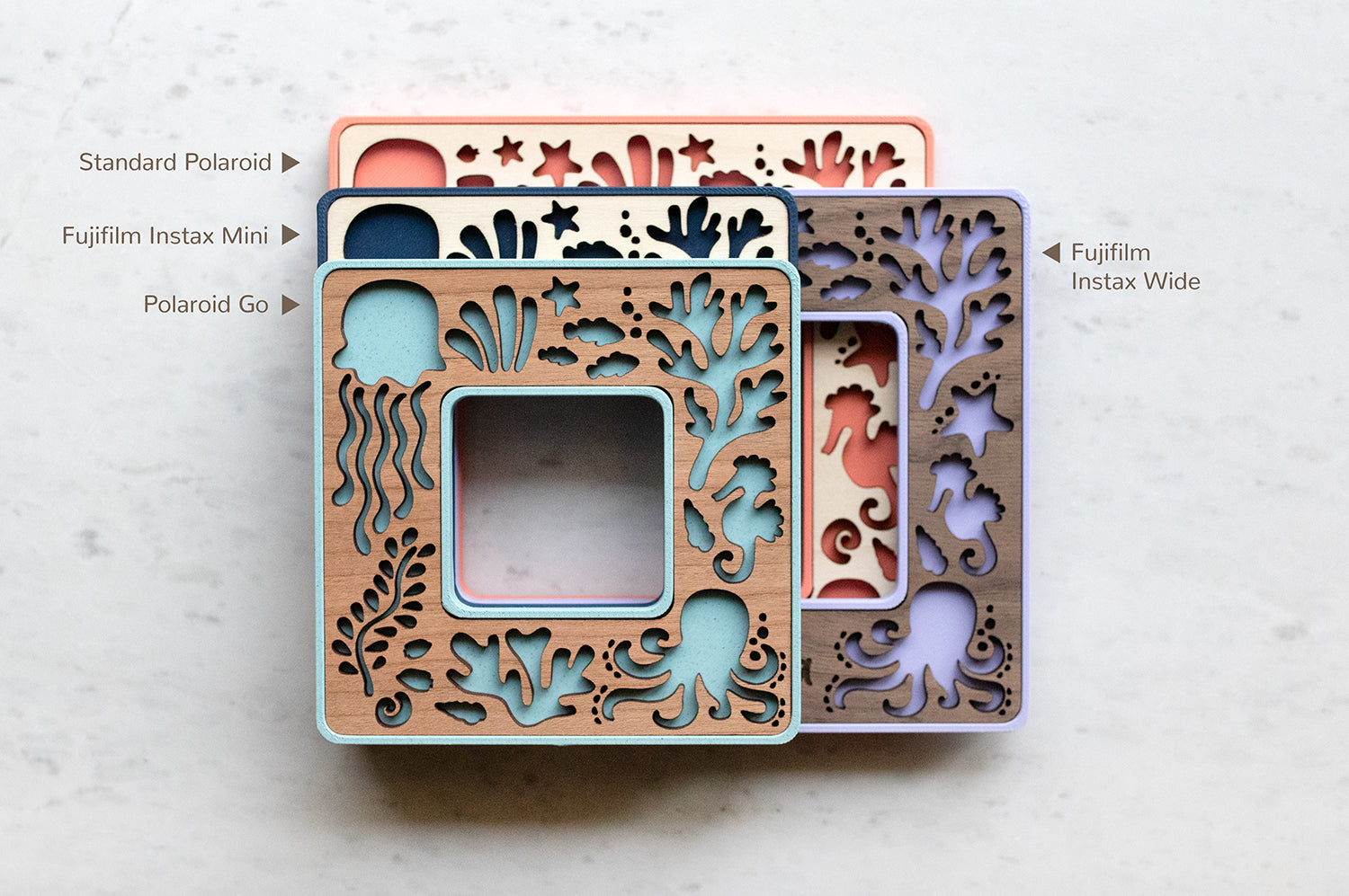 Four mini Polaroid frames and Instax mini and Instax wide frames in a stack. The frames feature laser cut ocean animals and ocean coral. Sizes include Polaroid Go, Standard Polaroid, Fujifilm Instax Mini, and Instax Wide.