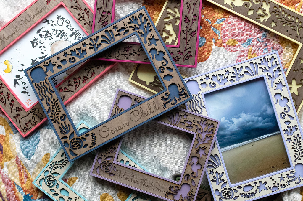 An assortment of whimsical, colorful, laser cut picture frames depicting scenes and creatures from ocean life. Frames are designed for beach houses, and they make a great gift for ocean lovers.