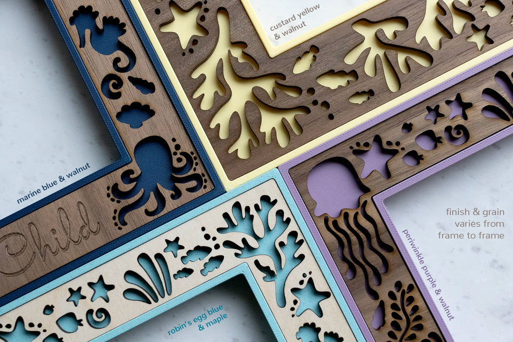 Detail view of four ocean themed picture frames in various colors. In view are laser cut elements including a jellyfish, an octopus, sea coral, starfish, seashells, and seaweed.
