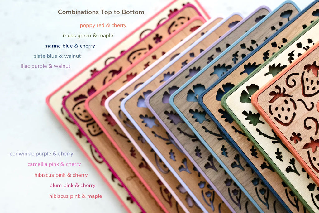 An assortment of ten magnetic frame colors with various wooden inlay types. Colors include: poppy red, moss green, marine blue, slate blue, lilac purple, periwinkle purple, camellia pink, hibiscus pink, and plum pink. The frames are displayed in a stack with corners visible to reveal possible color combinations.