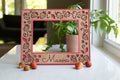 A whimsical strawberry frame featuring a bright pink frame and detailed laser cut strawberries in a custom cherry wooden inlay. Frames are available in 5x7, 4x6, Polaroid Instax Wide, and ultrasound frame sizes. The frame reads "Maeva" at the bottom and has strawberries next to it.