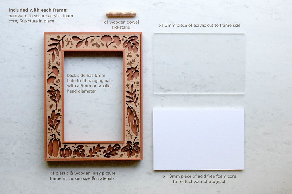 Flat lay of everything included with each fall leaves picture frame — a terracotta laser-cut wood-inlay frame with pumpkins and autumn leaves, a wooden dowel kickstand, a 3mm acrylic sheet cut to size, and a piece of acid-free foam core to protect your photo. Available in 4×6 and 5×7.