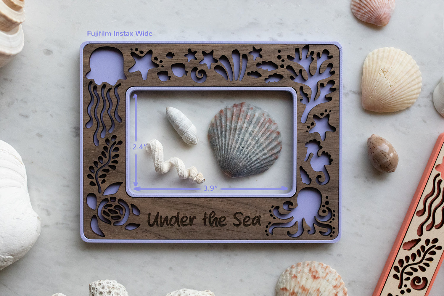 Instax wide purple beach frame that has a personalized "Under the Sea" message and cute sea creatures. The frame opening is 2.4" x 3.9" and is surrounded by seashells. The frame inlay is laser cut walnut wood.