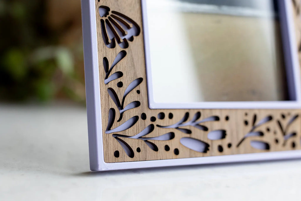 Close-up view of 4x6 floral picture frame with laser cut flowers and walnut inlay. Frame includes archival materials and high quality acrylic to protect photographs.